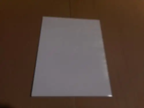 Weiße Abdeckhaube von Remeha auf einem neutralen, hellen Untergrund. Die Oberfläche ist glatt und reflektiert leicht das Licht.